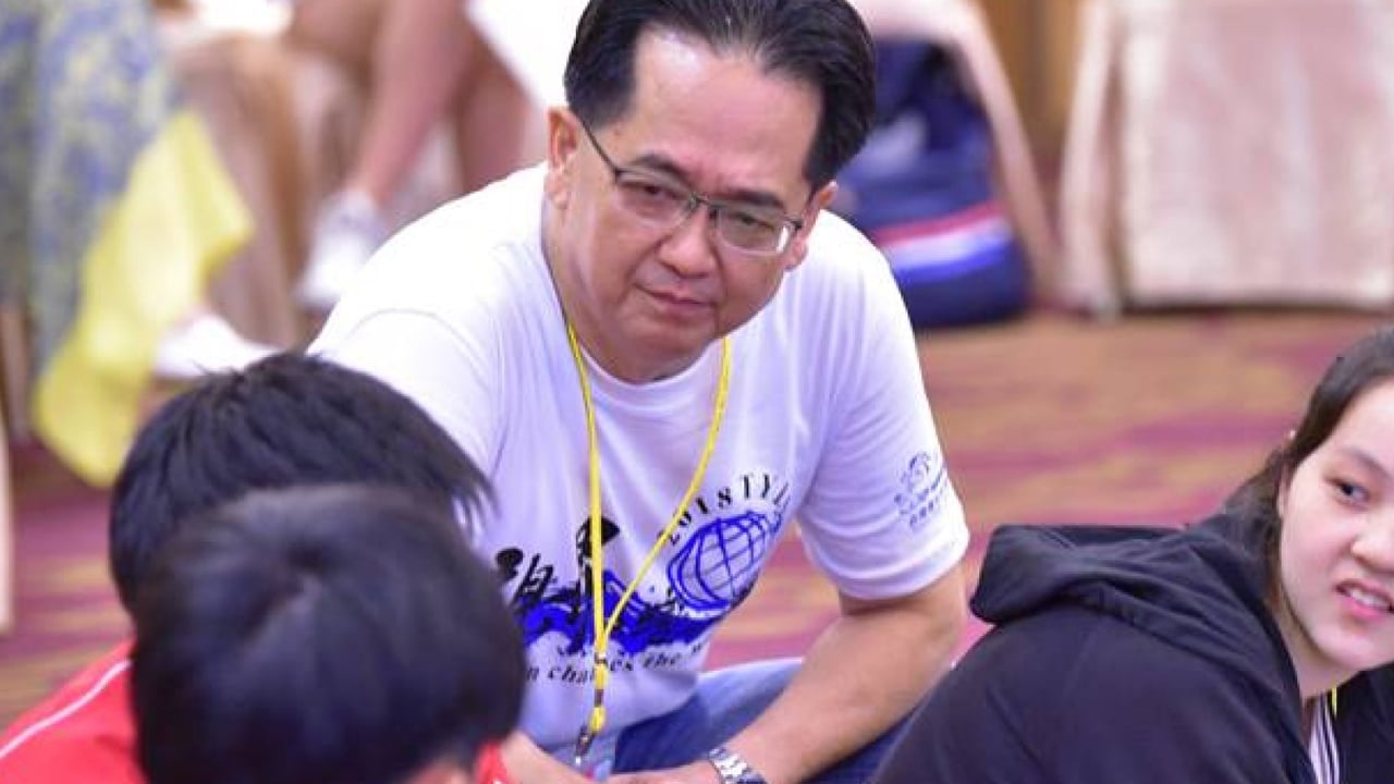 老師蹲在學員身旁引導討論
